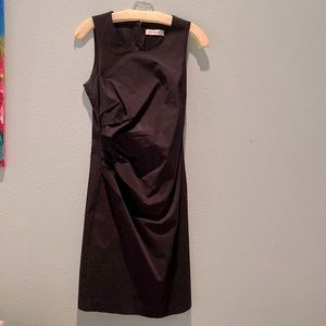 Sleeveless cotton black dress with side pleating.